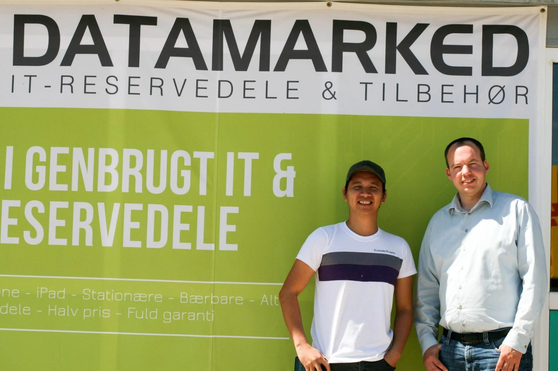 Ed Geronilla standing beside a colleague in front of a Datamarked store banner